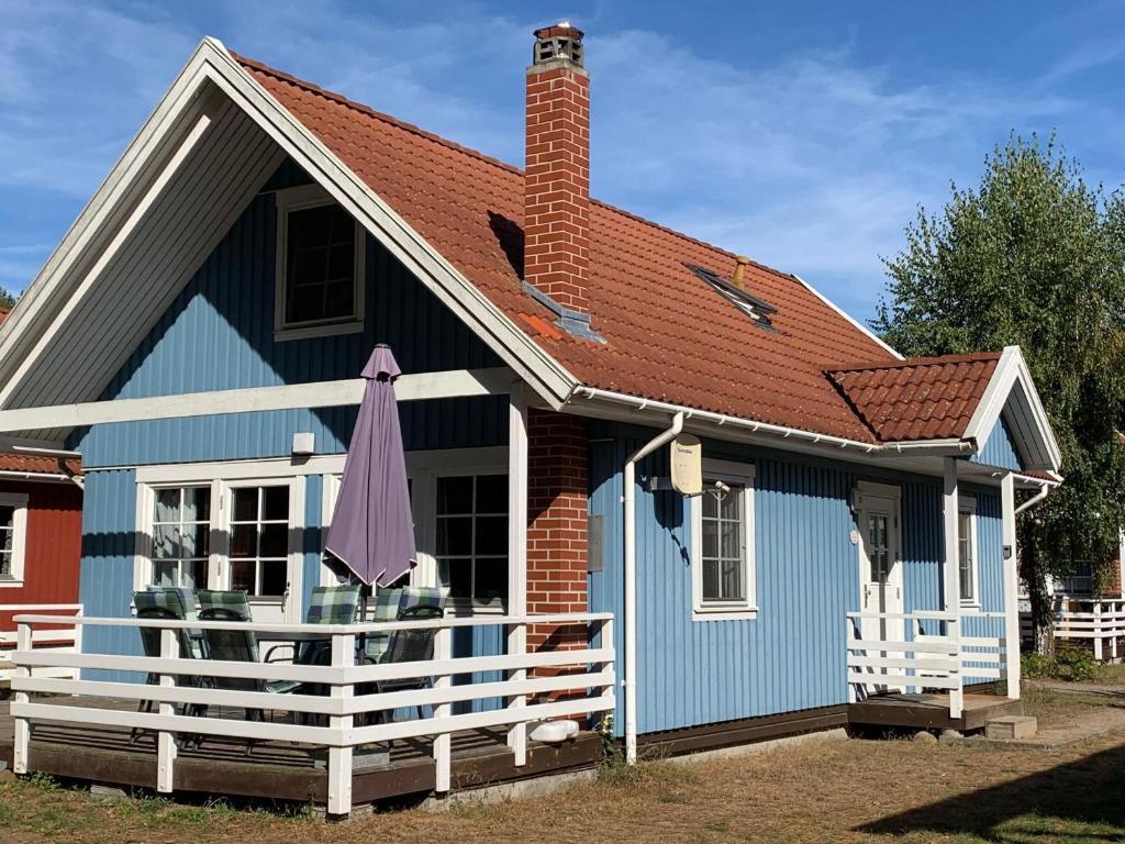 a blue and white house with a roof at Villa Blau am Useriner See mit Garten in Userin