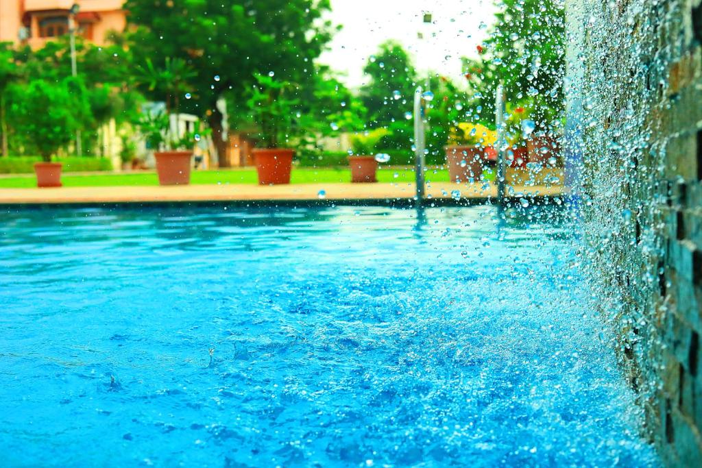une fontaine dans une piscine d'eau bleue dans l'établissement V One Pride, à Jaipur