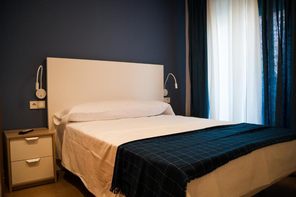 a bedroom with a bed and a window at Hostal Mónaco in Valladolid