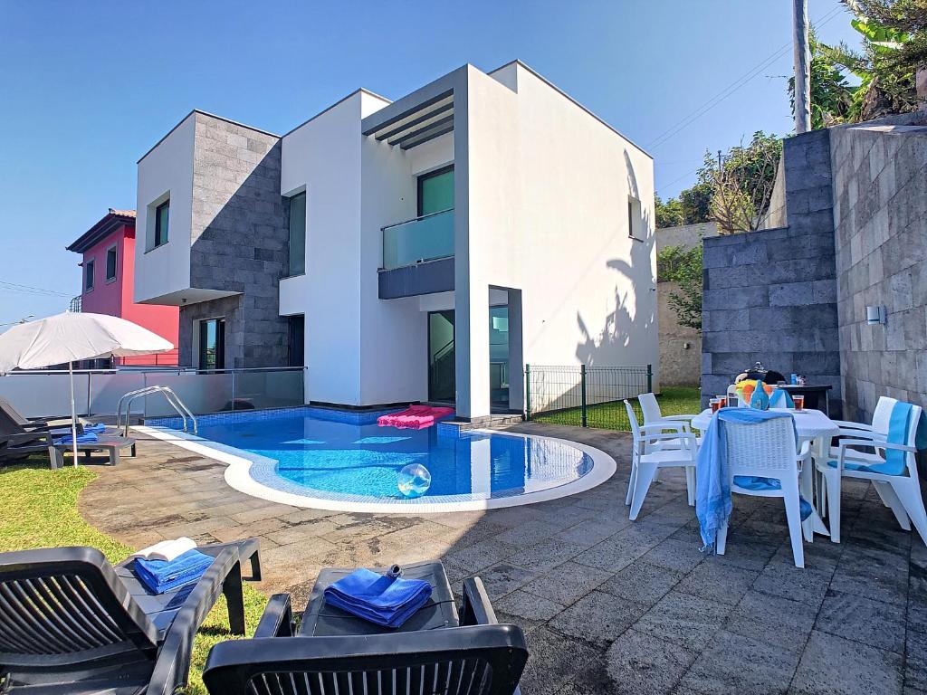 a patio with a table and chairs and a swimming pool at Villa North Sea by LovelyStay in Ponta Delgada