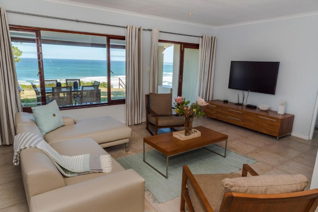 a living room with a couch and a television at Brenton Breakers in Brenton-on-Sea