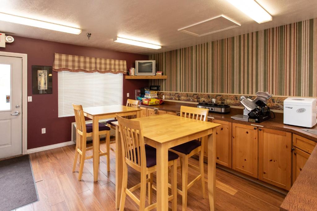 uma cozinha com uma mesa de madeira e cadeiras em The Kingsley Suites em Kingsley