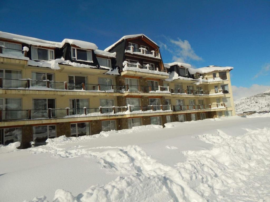 een gebouw bedekt met sneeuw met een berg sneeuw bij Catedral Ski & Summer in Bariloche