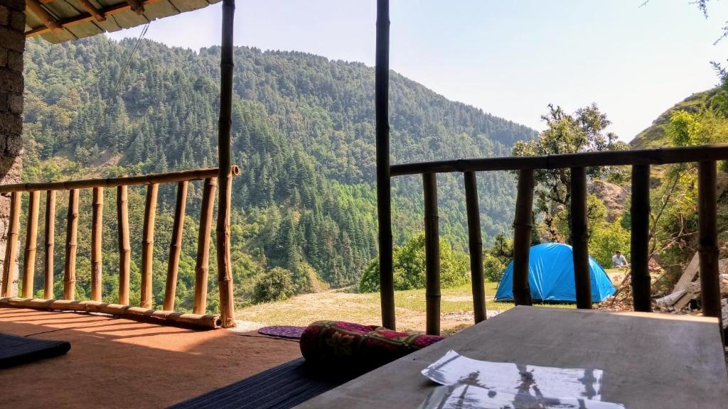 a table on a balcony with a view of a mountain at Ara Camps in McLeod Ganj