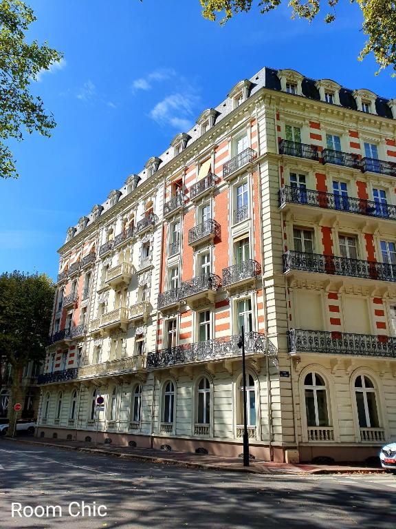 un grand bâtiment au bord d'une rue dans l'établissement RoomChic - Les Ambassadeurs, à Vichy