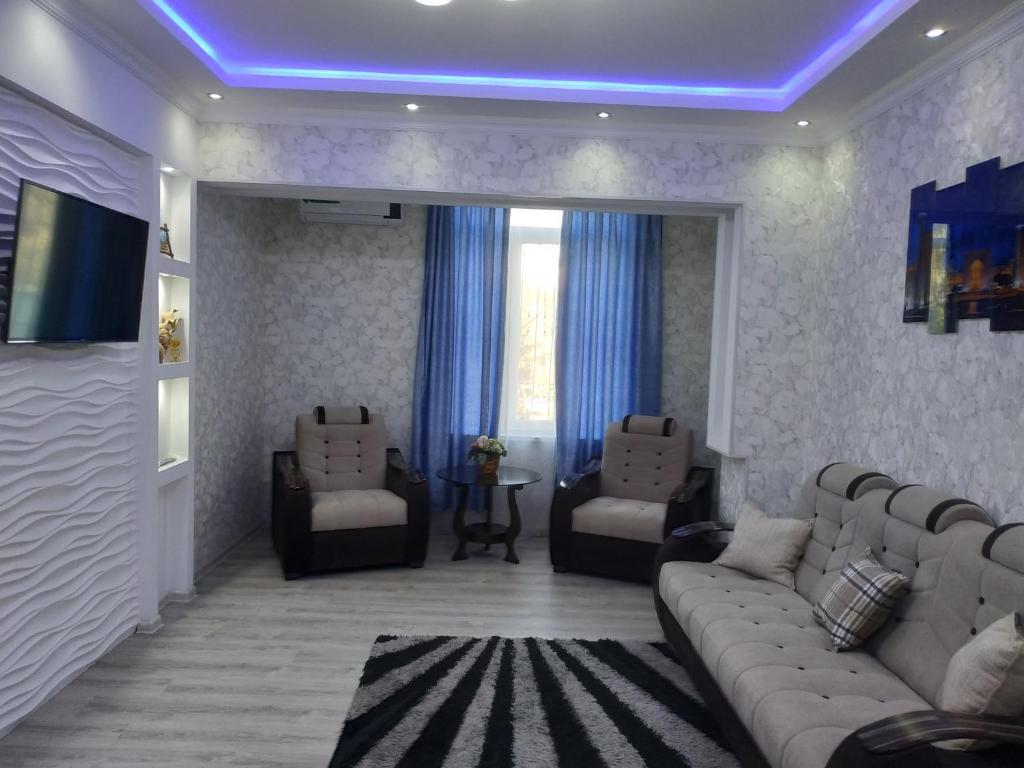 sala de estar con sofás y techo azul en Happy House, en Samarkand