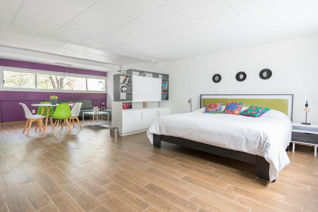 une chambre avec un lit, une table et des chaises dans l'établissement Deluxe Loft at Colonia ROMA, à Mexico
