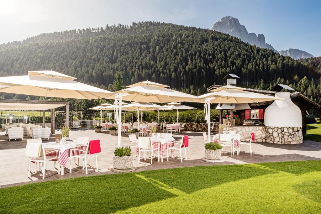 a restaurant with tables and chairs and umbrellas at Hotel Alpenroyal - The Leading Hotels of the World in Selva di Val Gardena