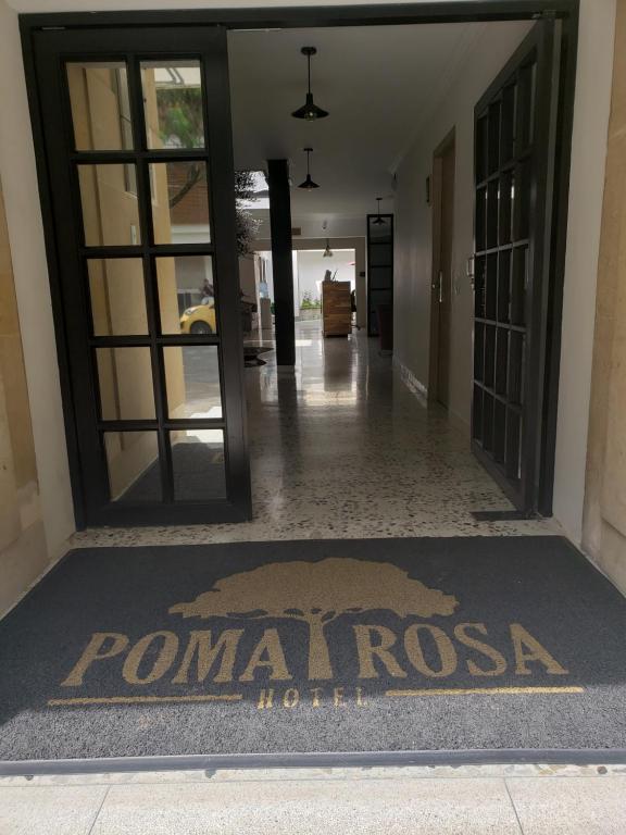 麥德林的住宿－Hotel Poma Rosa，大堂设有一张地毯上的扑曼尼奥萨酒店标志