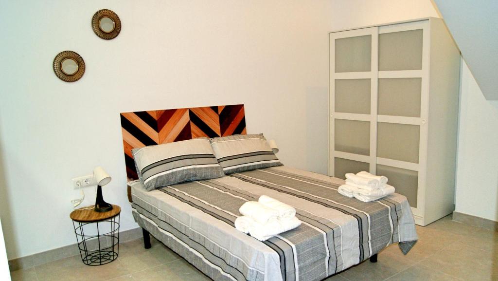 una camera da letto con un letto e asciugamani di Apartamento El Andén de la Estación a Málaga