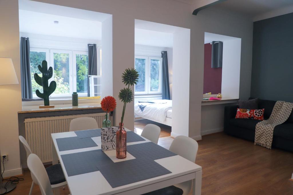 a living room with a table and a room with a bed at The garden flat in Luxembourg