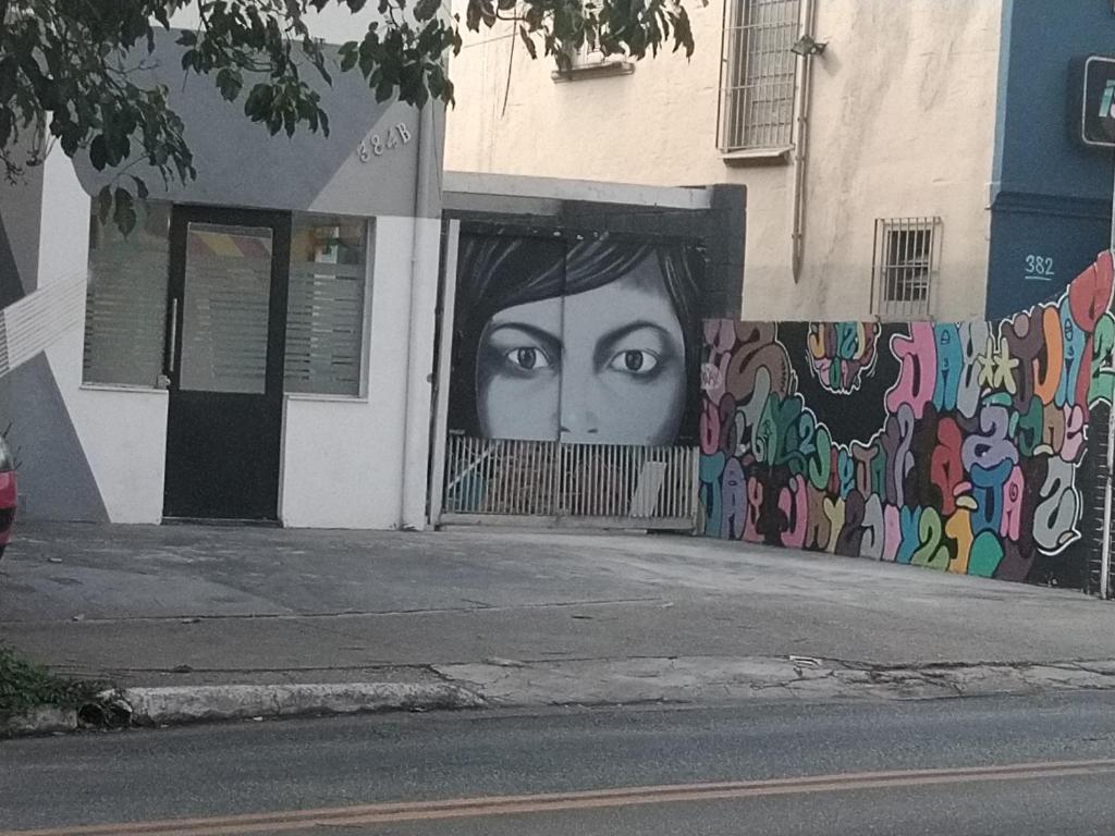 un mural de una mujer al lado de un edificio en NômadeHostel - Vila Madalena, en São Paulo