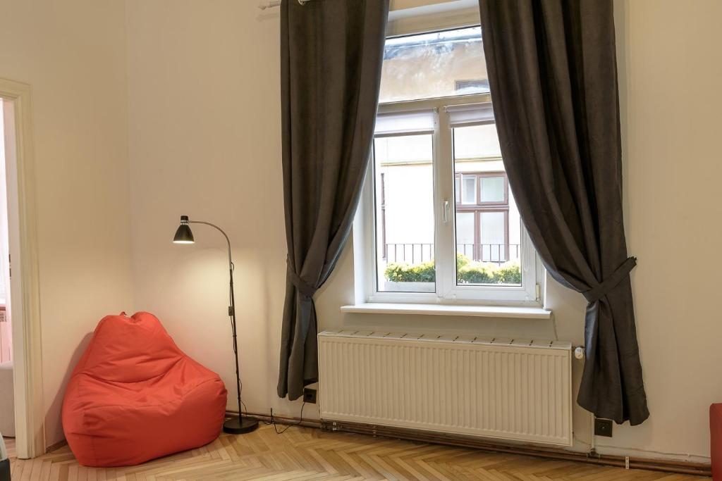 リヴィウにあるRed and Yellow Apartment Modernの窓前の赤豆袋付きの部屋