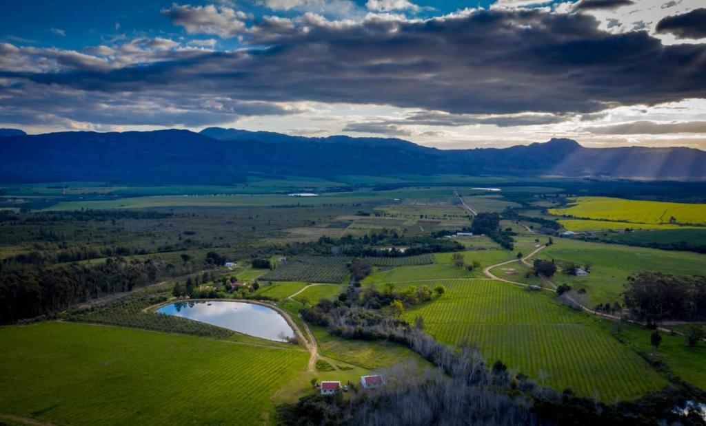 an aerial view of a field and a lake at Fraaigelegen Farm - Home of ADHARA EVOO in Tulbagh
