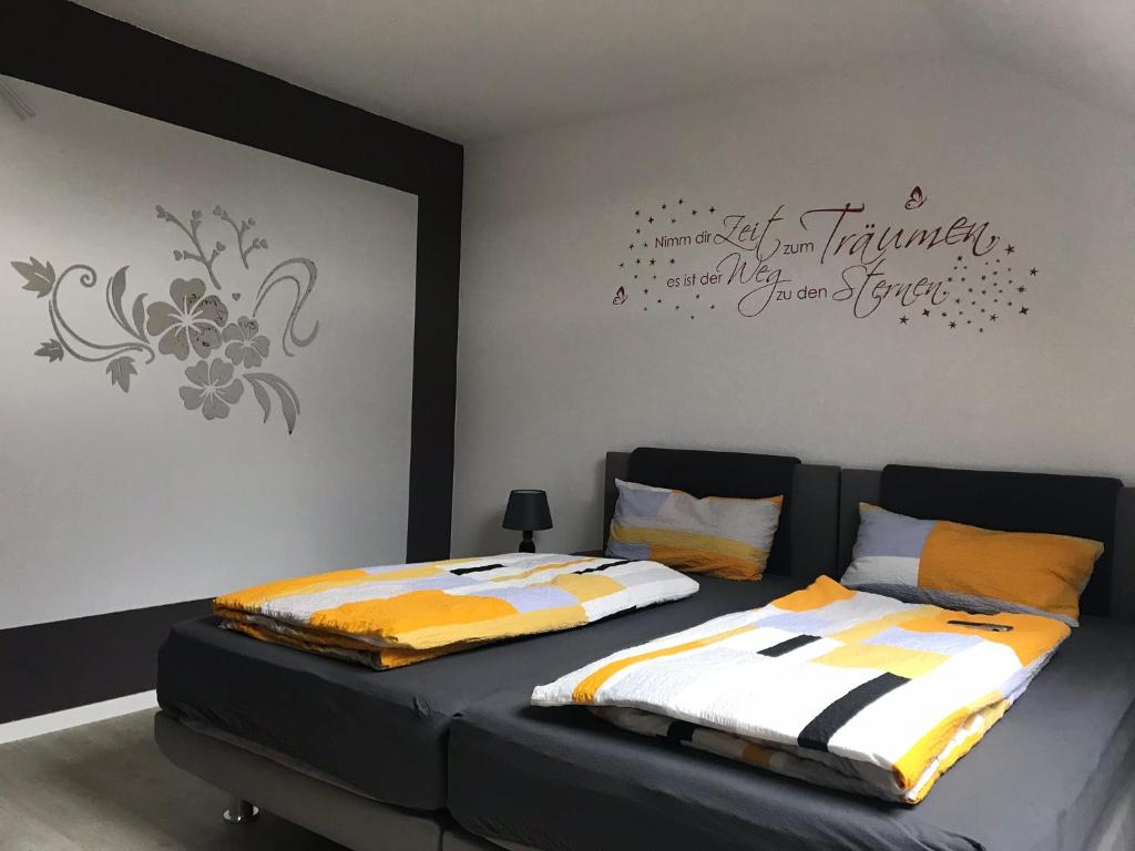 1 Schlafzimmer mit 2 Betten und einer Wand in der Unterkunft Ferienwohnung im Wonnegau Portugieser-Suite in Flörsheim-Dalsheim