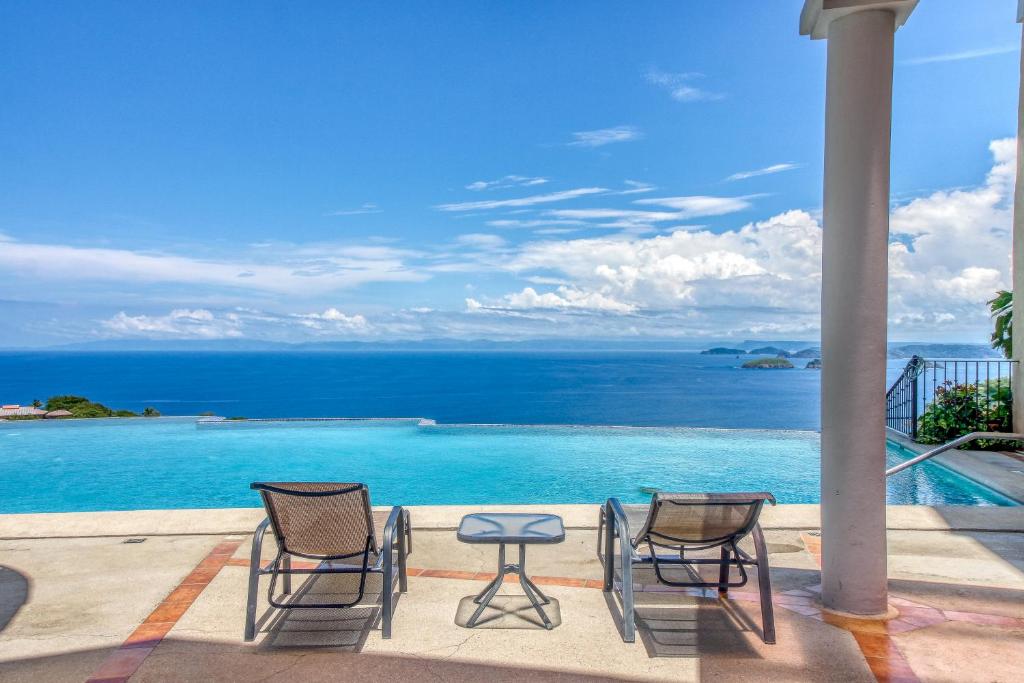 eine Terrasse mit Stühlen, einem Tisch und Meerblick in der Unterkunft Corona del Mar #6 in Ocotal