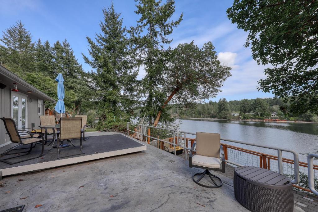 d'une terrasse avec une table et des chaises à côté d'une masse d'eau. dans l'établissement Heron Reach, à Gig Harbor