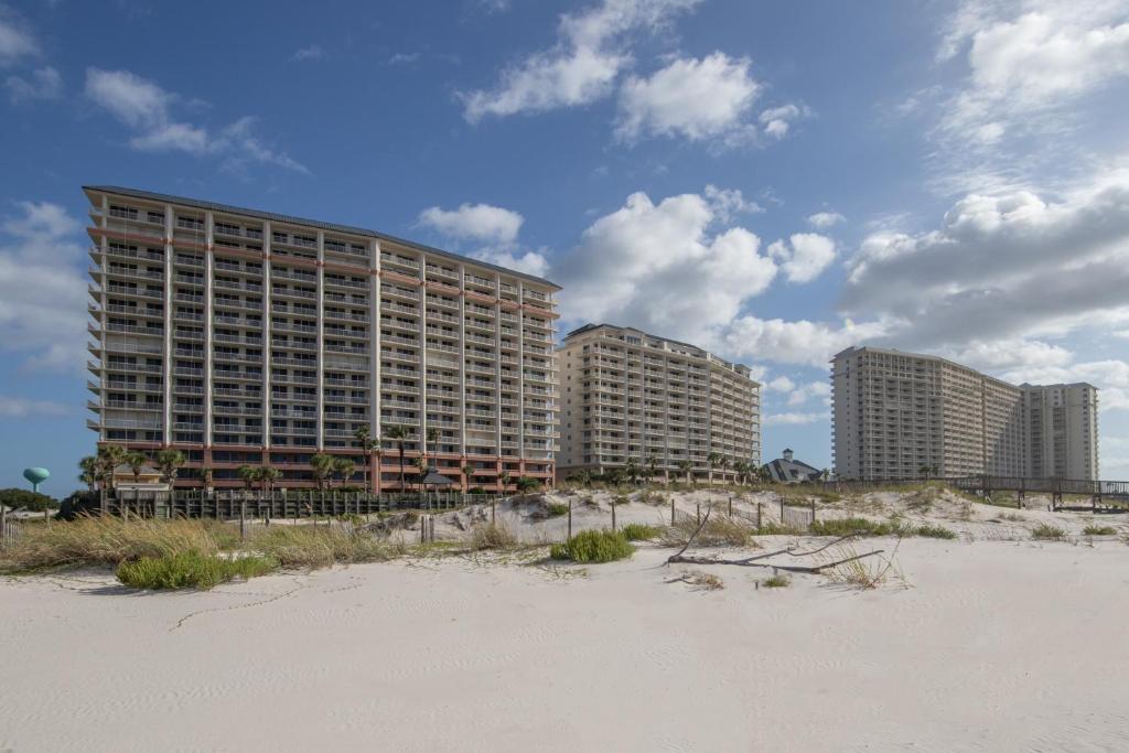 um hotel na praia com edifícios ao fundo em The Beach Club Resort and Spa II em Gulf Shores