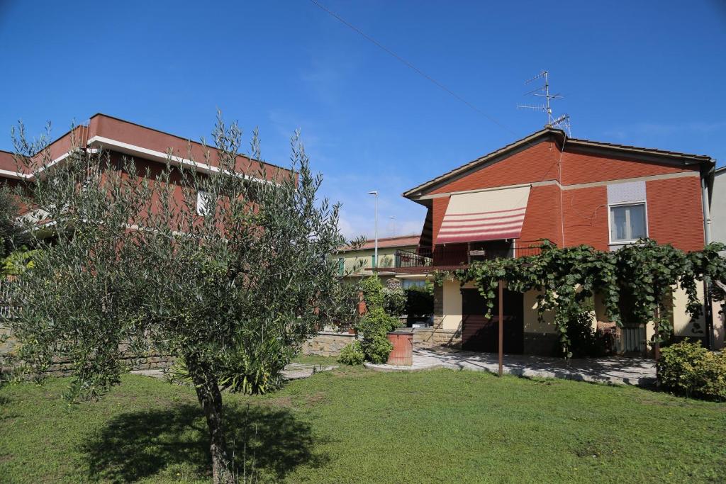 una casa con un albero di fronte a un cortile di Casa Cristina a Bolsena