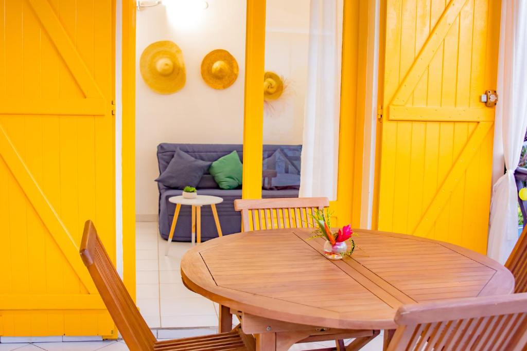 a dining room with a wooden table and a couch at Gîtes de Checheti in Trois-Rivières