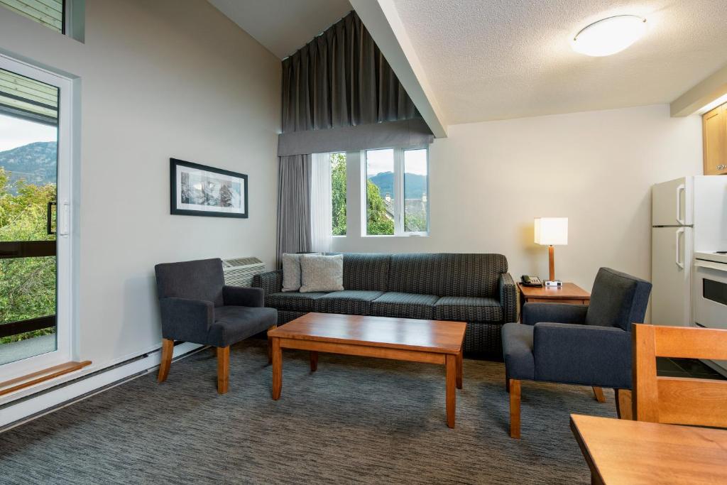 a living room with a couch and chairs and a table at Whistler Village Inn & Suites in Whistler