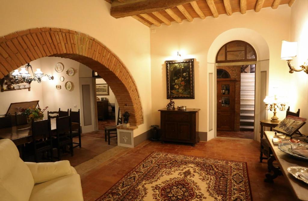 uma sala de estar com um arco e uma sala de jantar em I Tre Poderi 1872 em Treggiaia