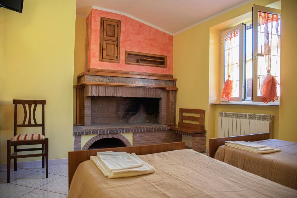 a bedroom with two beds and a fireplace at B&B IL FILO DI ARIANNA in LʼAquila