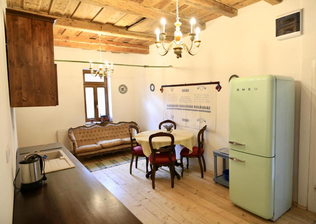 a kitchen with a table and a refrigerator in a room at Casa Eva Wagner - Biertan in Biertan