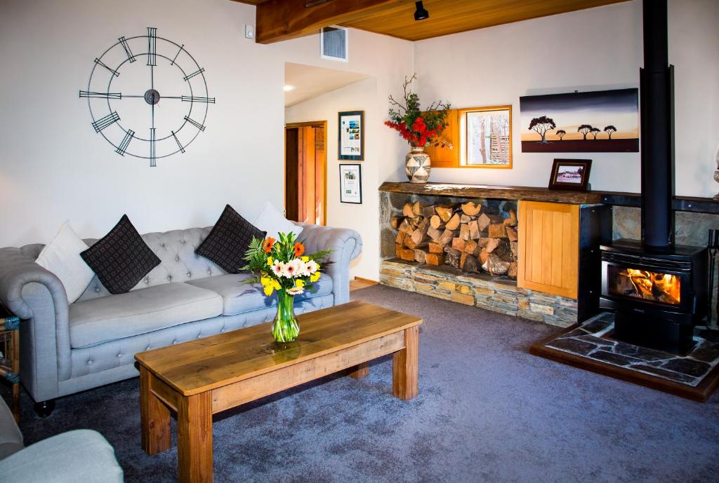 a living room with a couch and a fireplace at Te Wanaka Lodge in Wanaka