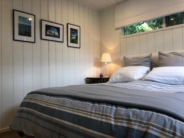 a bedroom with a large bed and a window at Hahei Kereru Cottage in Hahei