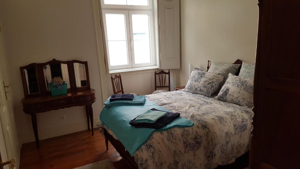 a bedroom with a bed with a mirror and a window at Grandmommy's House - Traditional and comfy Lisboan apartment in Lisbon