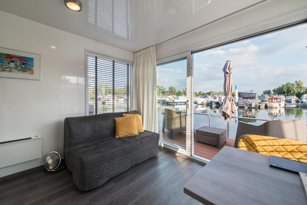 a living room with a couch and a large window at Boatlodge Antigua in Maastricht