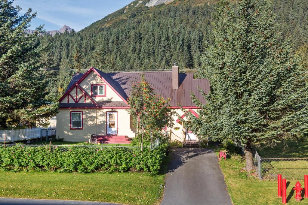 a house in the mountains with a road leading to it at Seward's Guest House in Seward