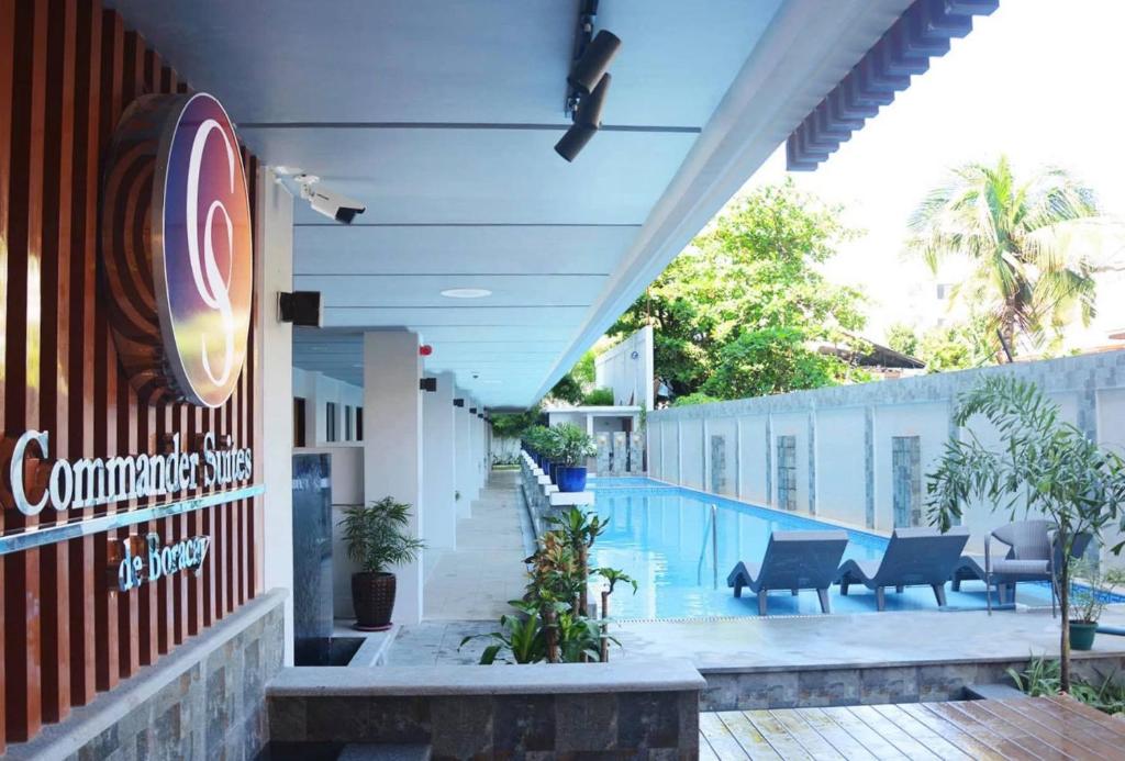 a building with a pool and a sign on it at Commander Suites de Boracay in Boracay