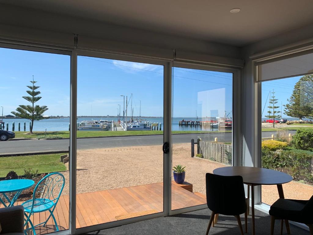 a room with sliding glass doors with a view of the ocean at Boat Harbour Jetty B&B in Port Albert