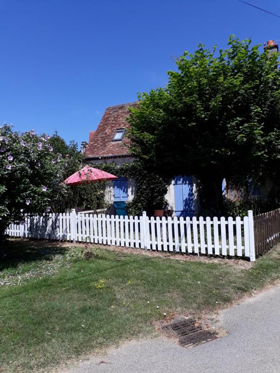 a white picket fence in front of a house at La maison de Xenos in Nohant-en-Graçay
