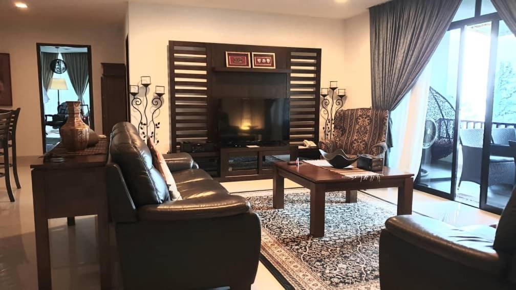 a living room with two couches and a television at Samsuria Exclusive Beach Penthouse in Kampung Sungai Ular