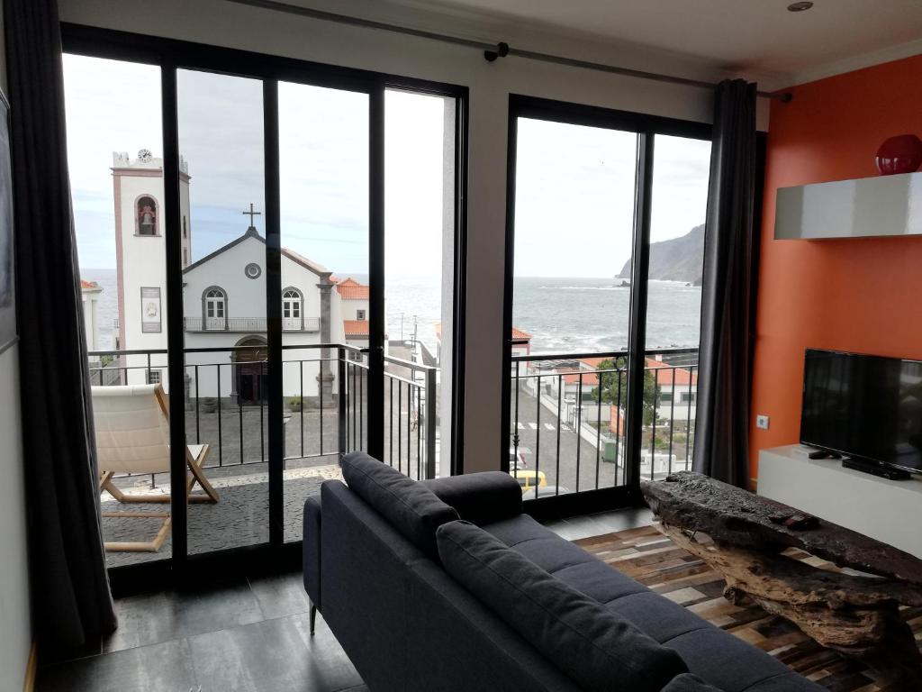 a living room with a couch and a view of the ocean at Casa Abreu in Ponta Delgada
