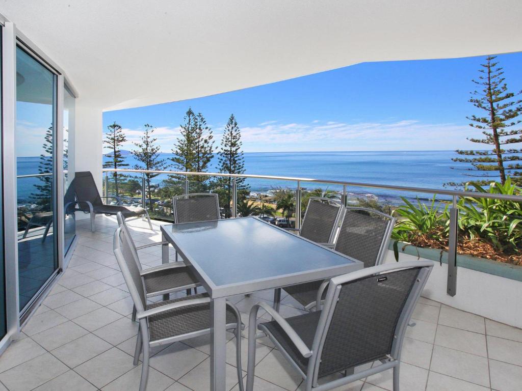 a table and chairs on a balcony with the ocean at Sirocco 506 in Mooloolaba