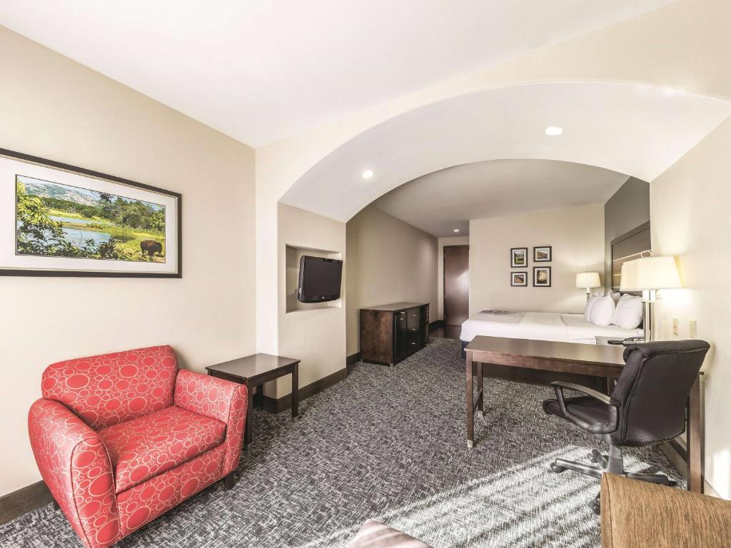 a hotel room with a bed and a desk at La Quinta by Wyndham Tulsa - Catoosa in Catoosa