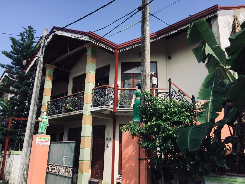 a building with a balcony with a man on it at Bee Nest Bed & Breakfast in Negombo