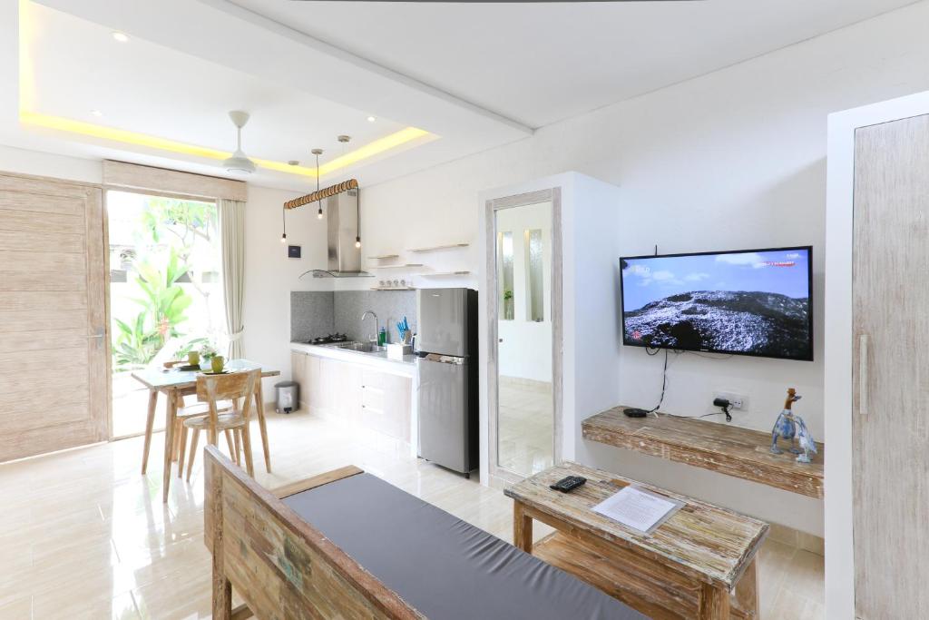 a living room with a flat screen tv on a wall at Green Studio Apartment Sanur in Sanur