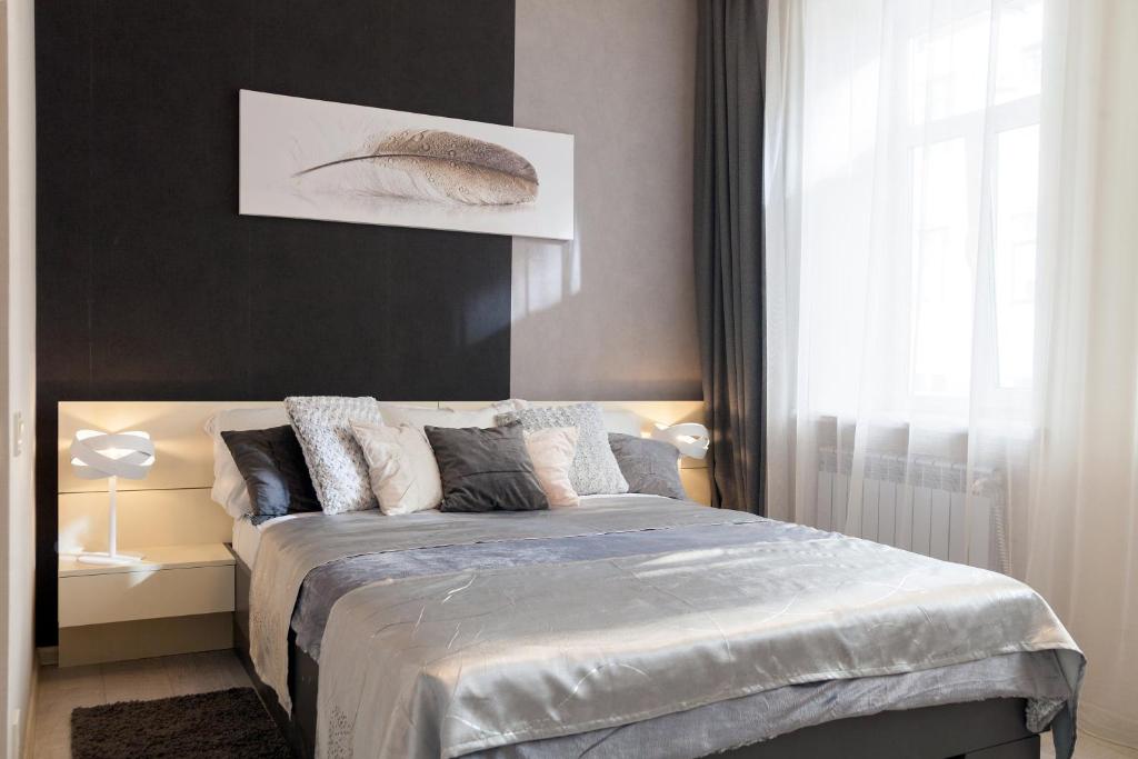 a bedroom with a bed with pillows on it at City Center Apartments in Lviv
