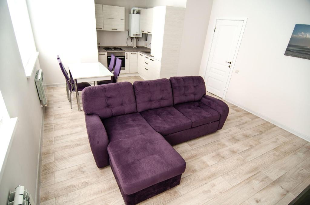 ソチにあるАпартаменты в Сочиの紫色のソファとテーブル付きのリビングルーム