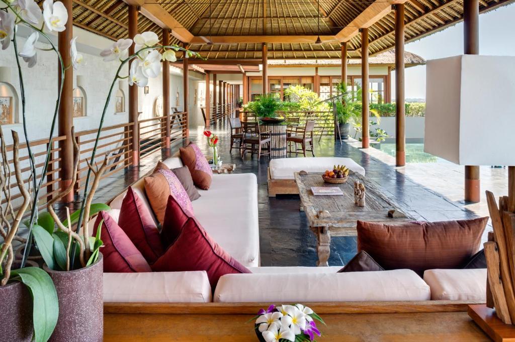 Una sala de estar con sofás y mesas blancos. en The Longhouse, Jimbaran - Bali, en Jimbaran