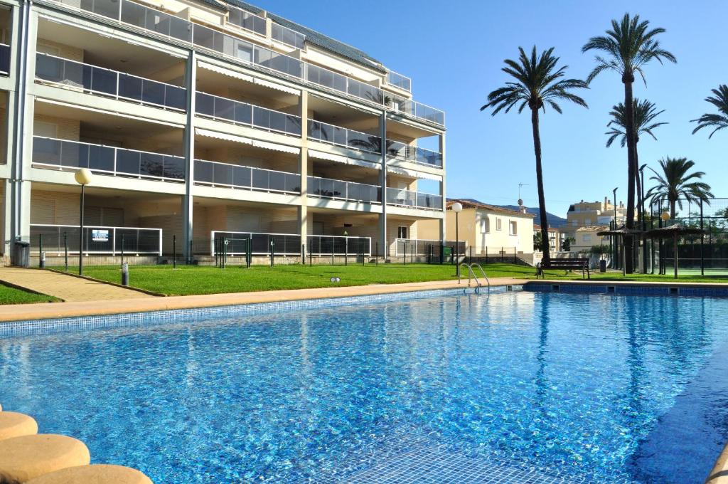 una grande piscina di fronte a un edificio di Brisas A1, 2 dormitorios, playa a 50m, by Bookindenia a Denia