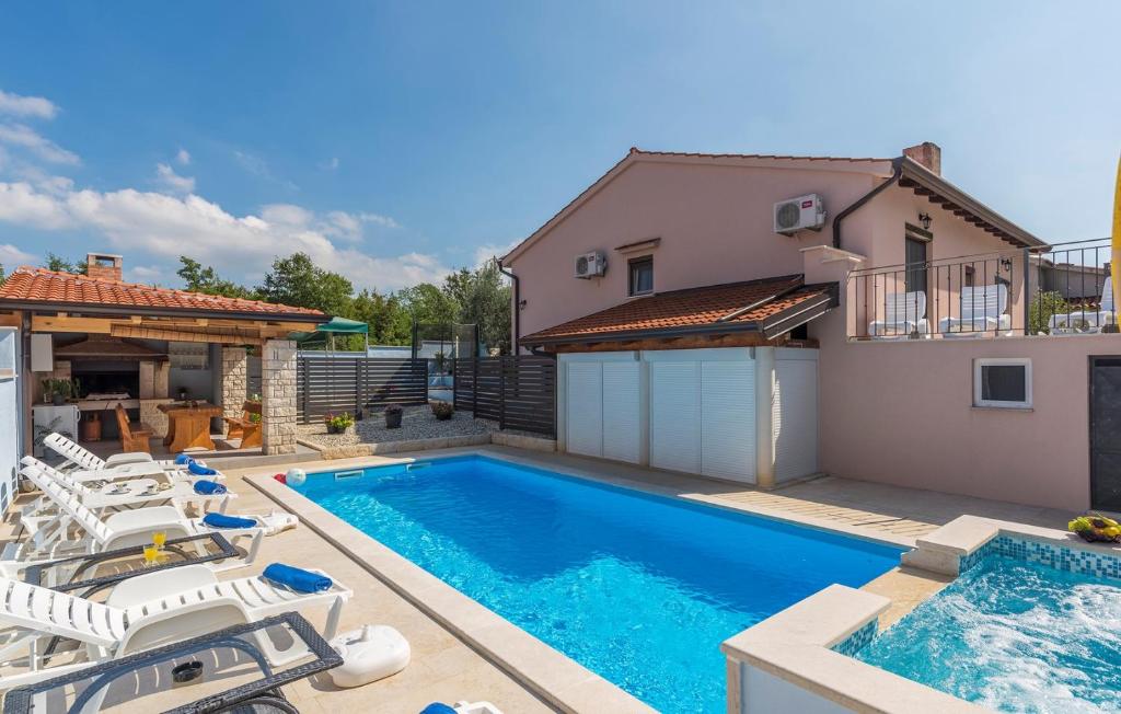 a swimming pool with chairs and a house at Apartment Leon in Nova Vas