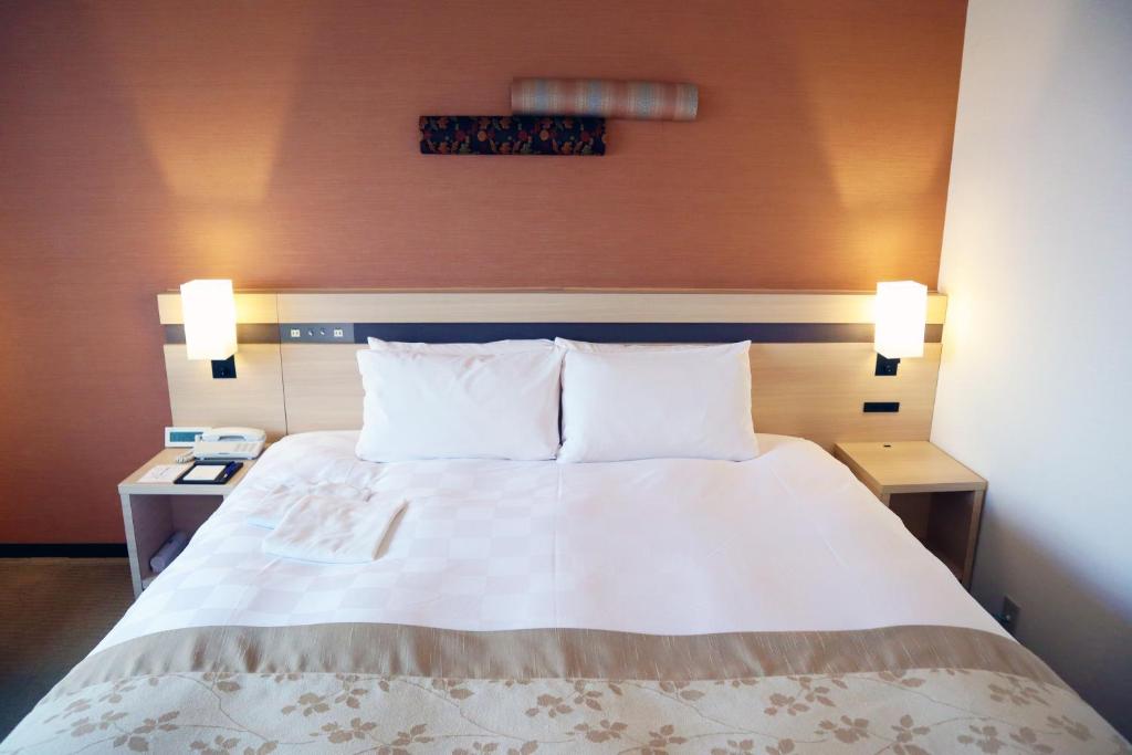 Postel nebo postele na pokoji v ubytování Karasuma Kyoto Hotel