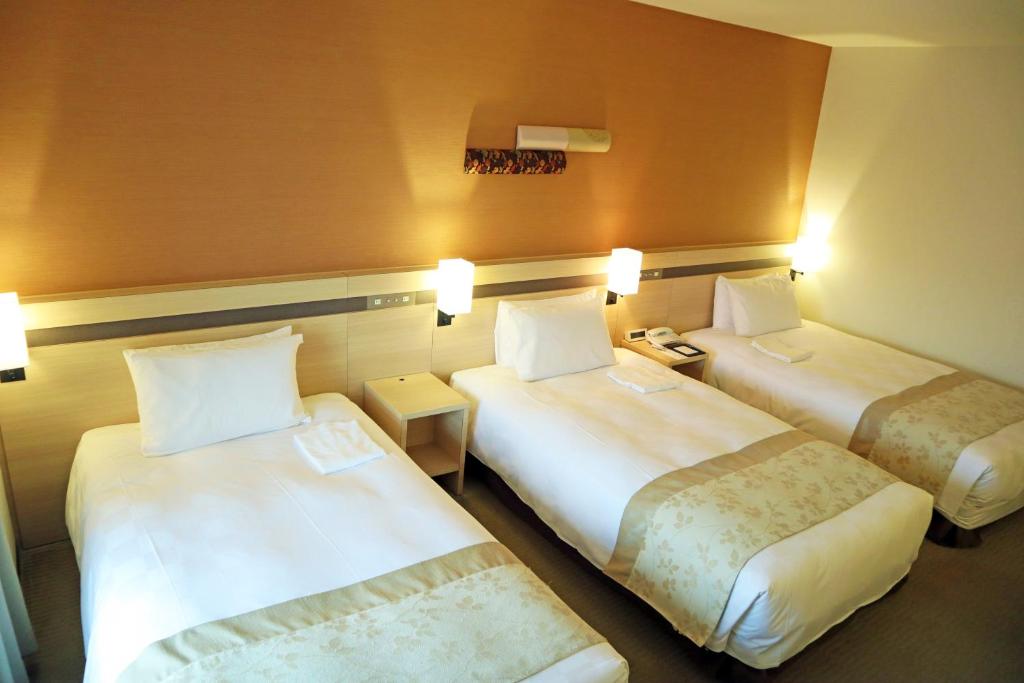 Postel nebo postele na pokoji v ubytování Karasuma Kyoto Hotel