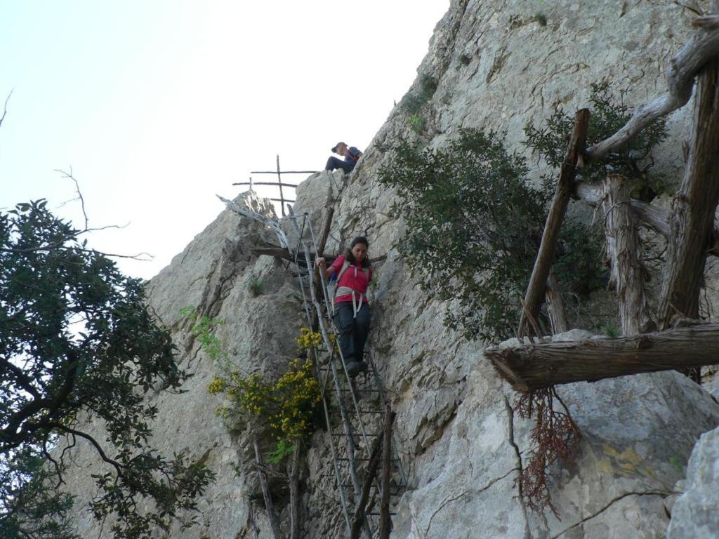 a person climbing up a mountain on a ladder at Hotel Bia Maore in Baunei